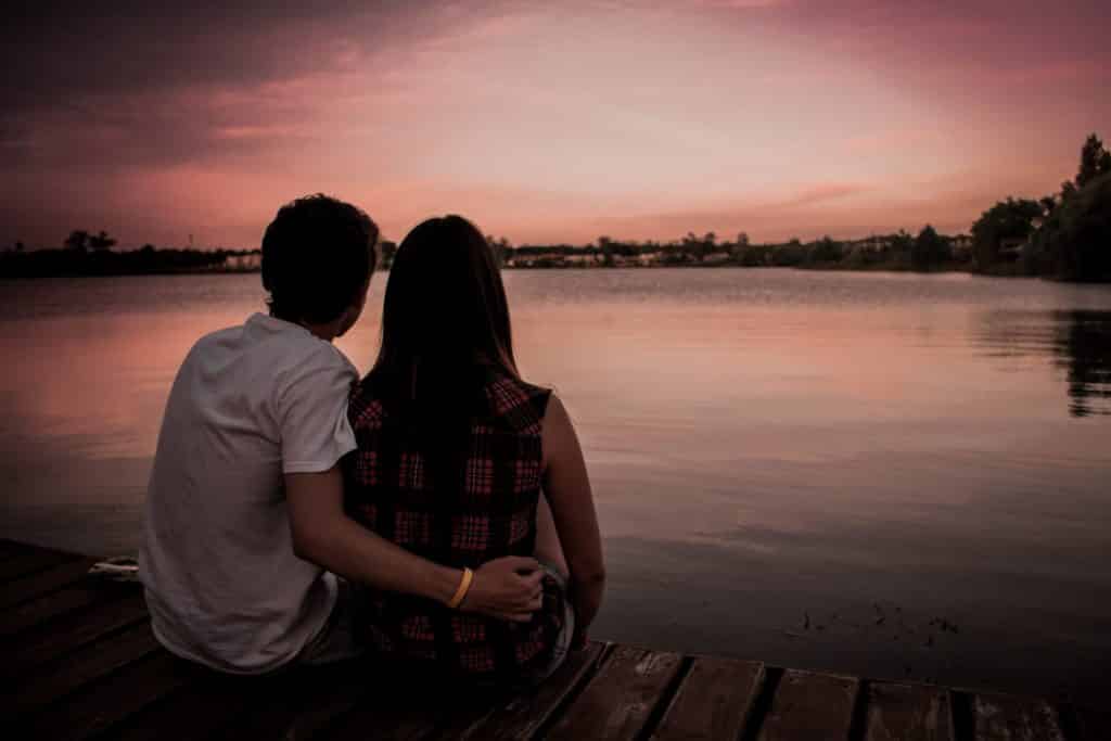 man and woman sitting on dock